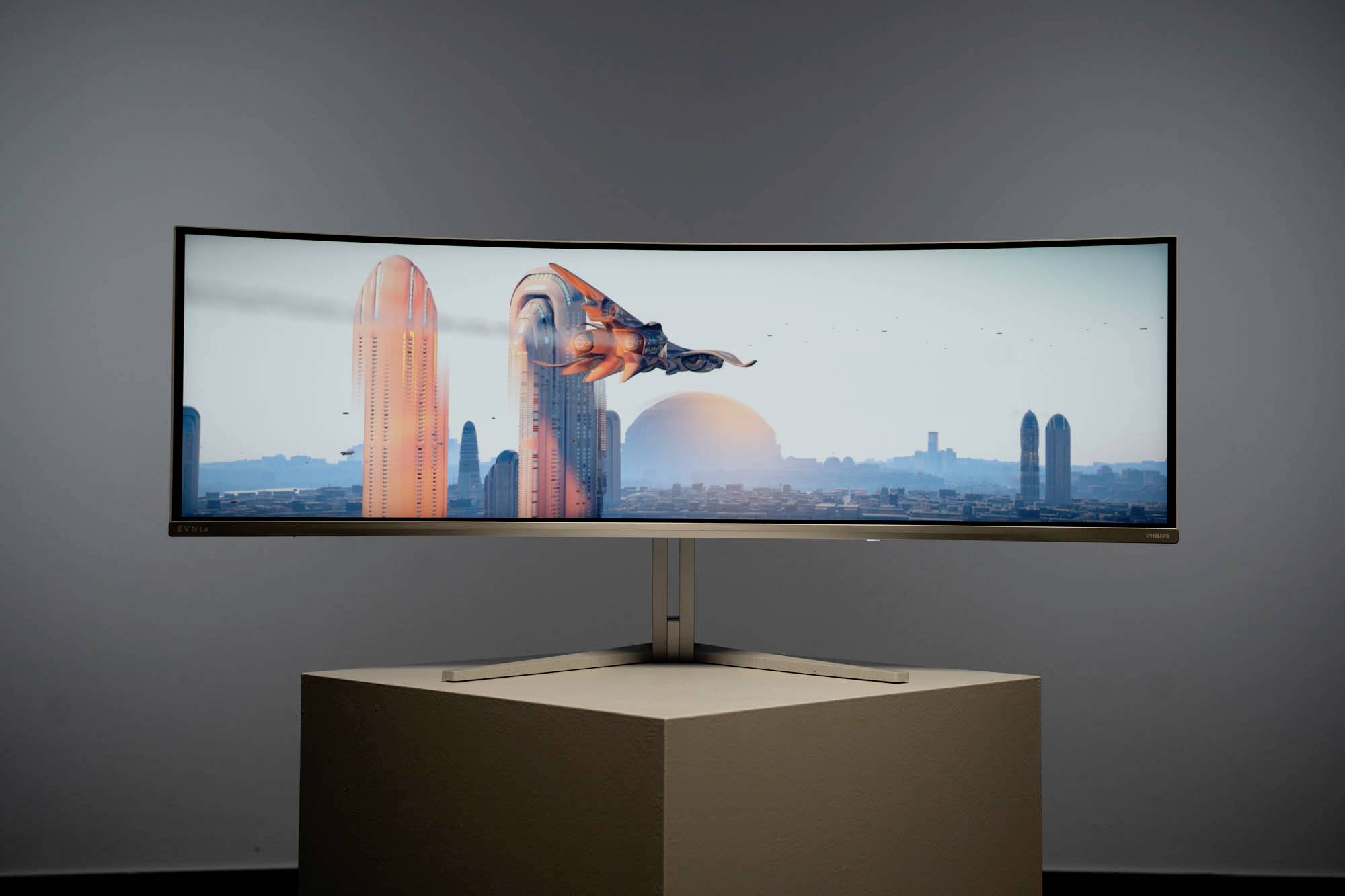 Ein großer, gebogener Bildschirm zeigt eine futuristische Stadt. Im Vordergrund fliegt gleitendes Fahrzeug zwischen hohen Gebäuden.