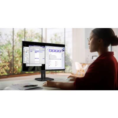 Eine Person arbeitet am Computer mit zwei Monitoren. Auf den Bildschirmen sind Kalender- und Kommunikations-Apps geöffnet.