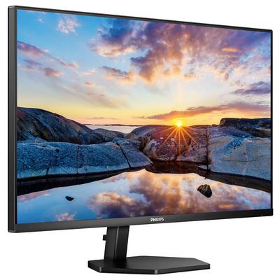 Ein Monitor zeigt ein lebhaftes Bild eines Sonnenuntergangs über felsigen Küsten mit reflektierendem Wasser im Vordergrund.