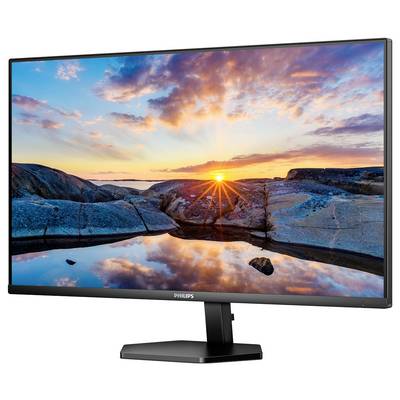 Ein Monitor zeigt ein Landschaftsbild mit Sonnenuntergang über Felsen und Wasser, der Himmel ist orange-rosa gefärbt.