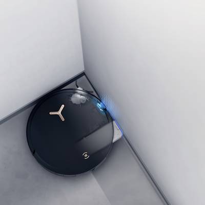 Ein schwarzer Saugroboter reinigt eine Ecke eines Raumes. Die blauen Lichter zeigen an, dass der Roboter in Betrieb ist.