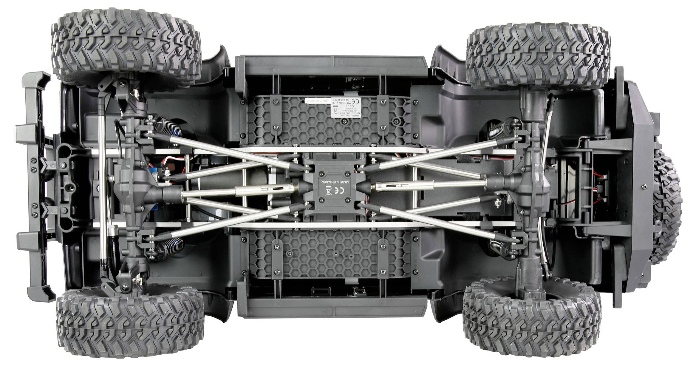 'Unterseite eines ferngesteuerten Geländewagens mit detailliert sichtbarer Aufhängung und großen Reifen.'