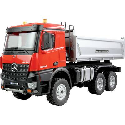 Roter Lastwagen mit grauer Ladefläche, Mercedes-Benz-Logo vorne sichtbar. Verschnallt mit Bauausrüstung.