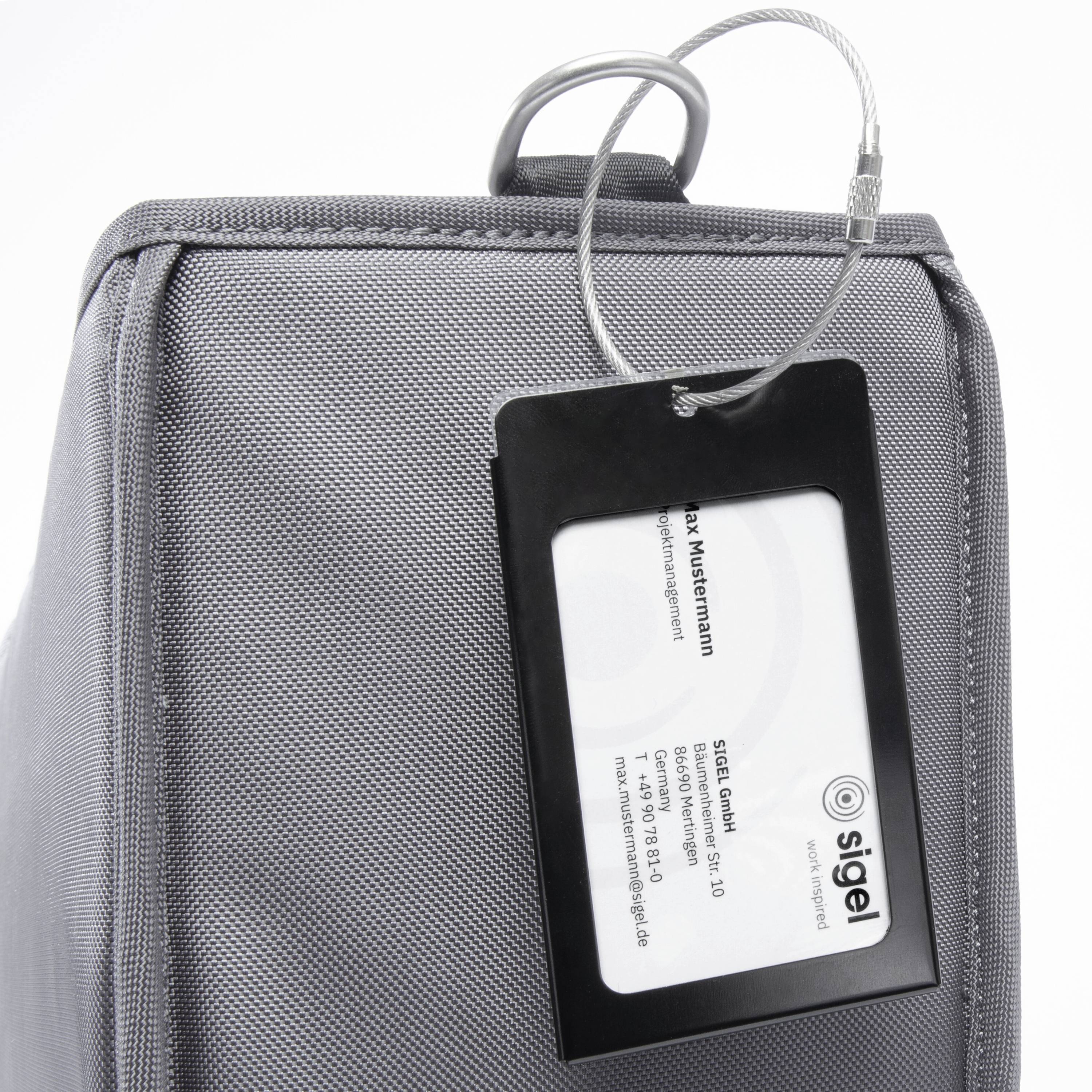 Graue Tasche mit Namensschild an einer Seite, darauf steht 'Max Mustermann', darunter die Adresse von "SIGEL GmbH".