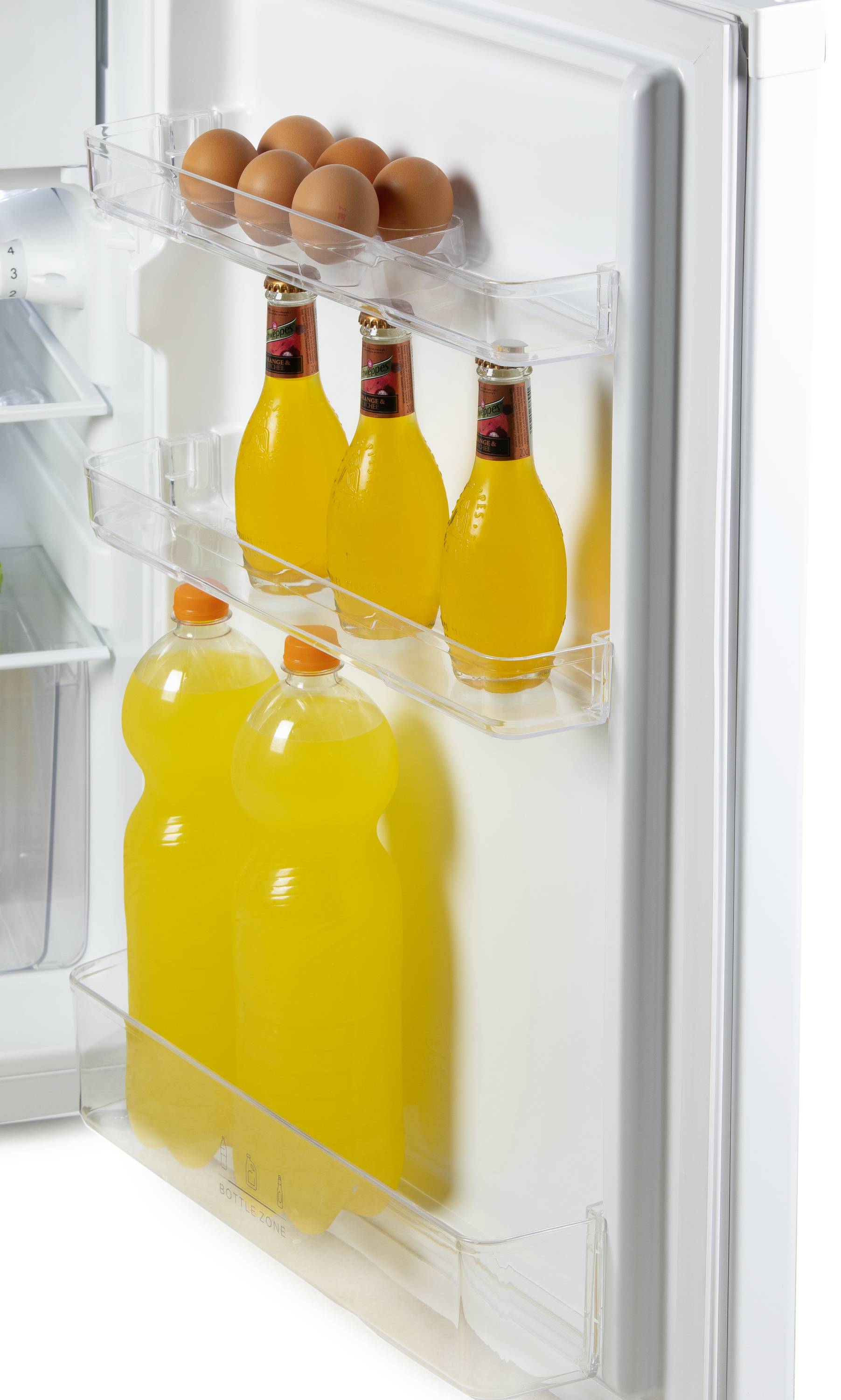 Kühlschranktür mit Fächern: Oben sechs Eier, darunter vier Flaschen, gefolgt von zwei großen PET-Flaschen mit gelbem Inhalt.