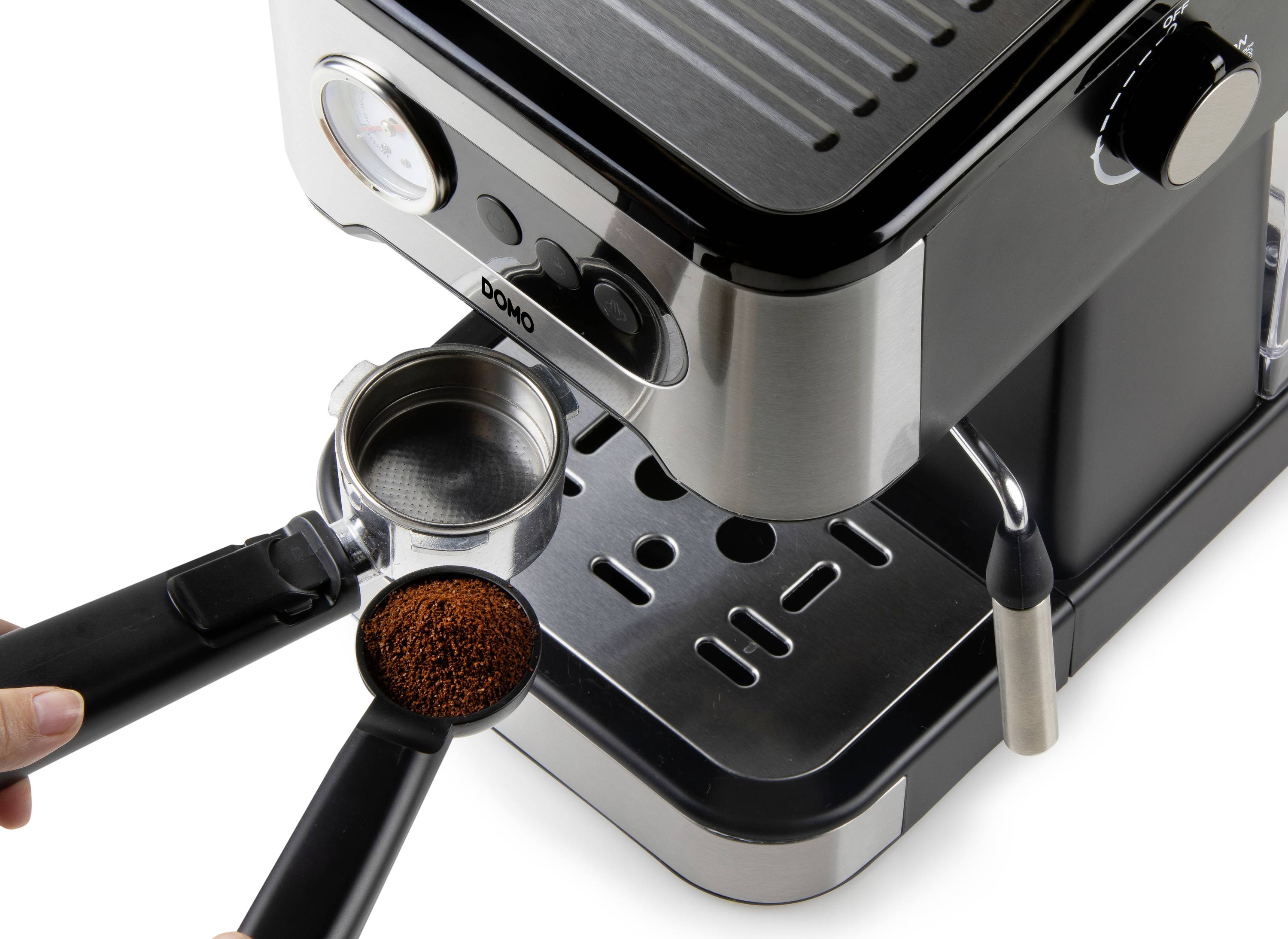 Person füllt Kaffeepulver in einen Siebträger einer Espressomaschine. Die Maschine ist metallisch mit schwarzem Finish.