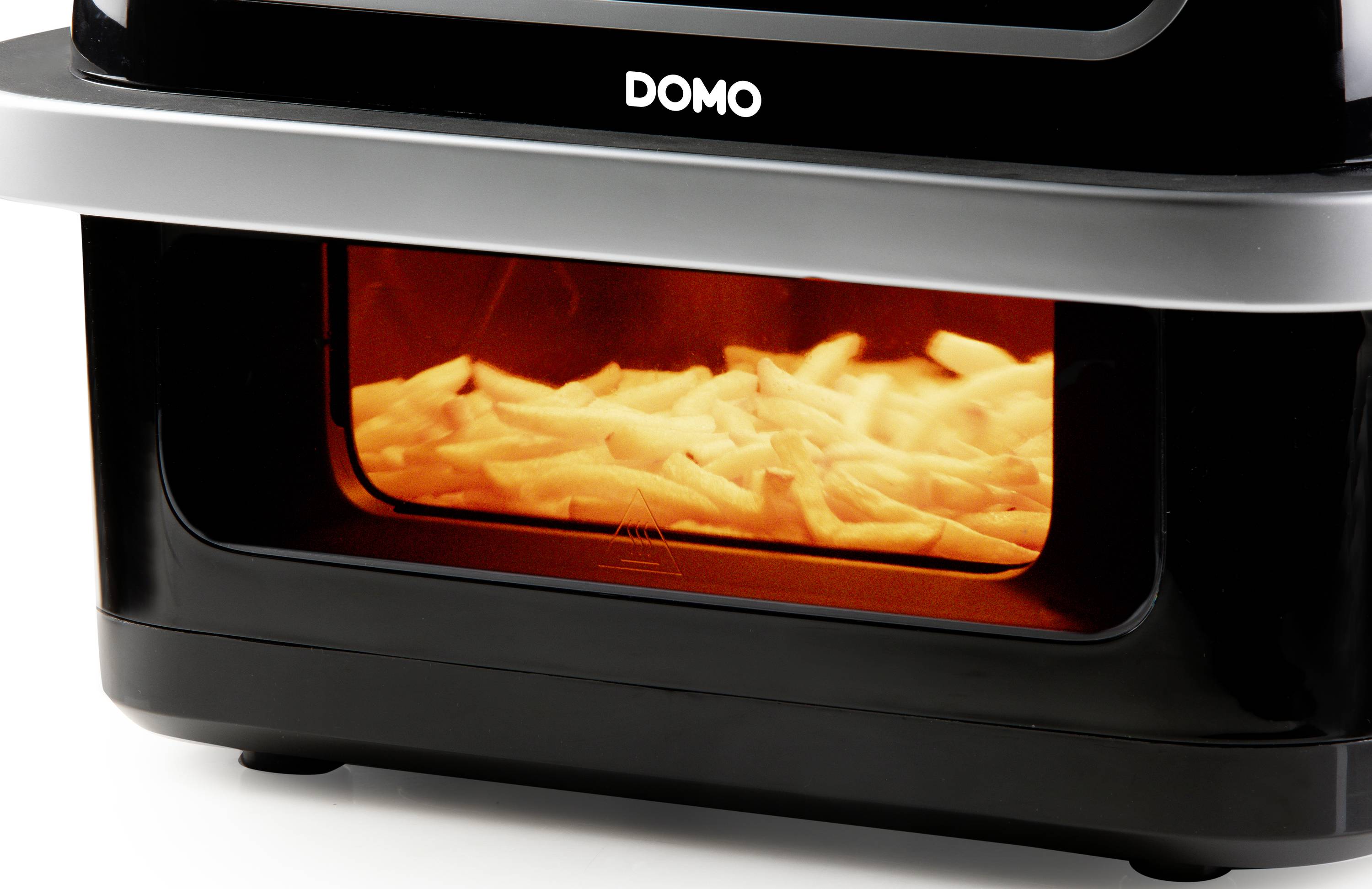 'Fritteuse mit Pommes frites im Garvorgang, dargestellt durch die rot-orange Beleuchtung des Innenraums.'