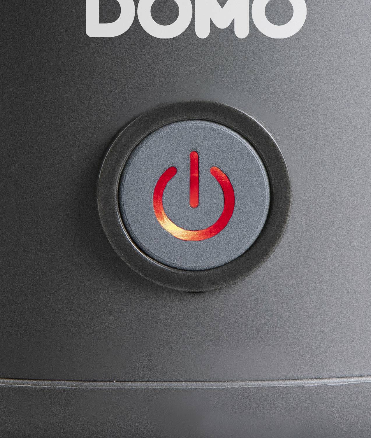 Ein leuchtender roter Ein-/Ausschalter auf einem schwarzen elektrischen Gerät, oberhalb der Taste befindet sich das Wort 'DOMO'.
