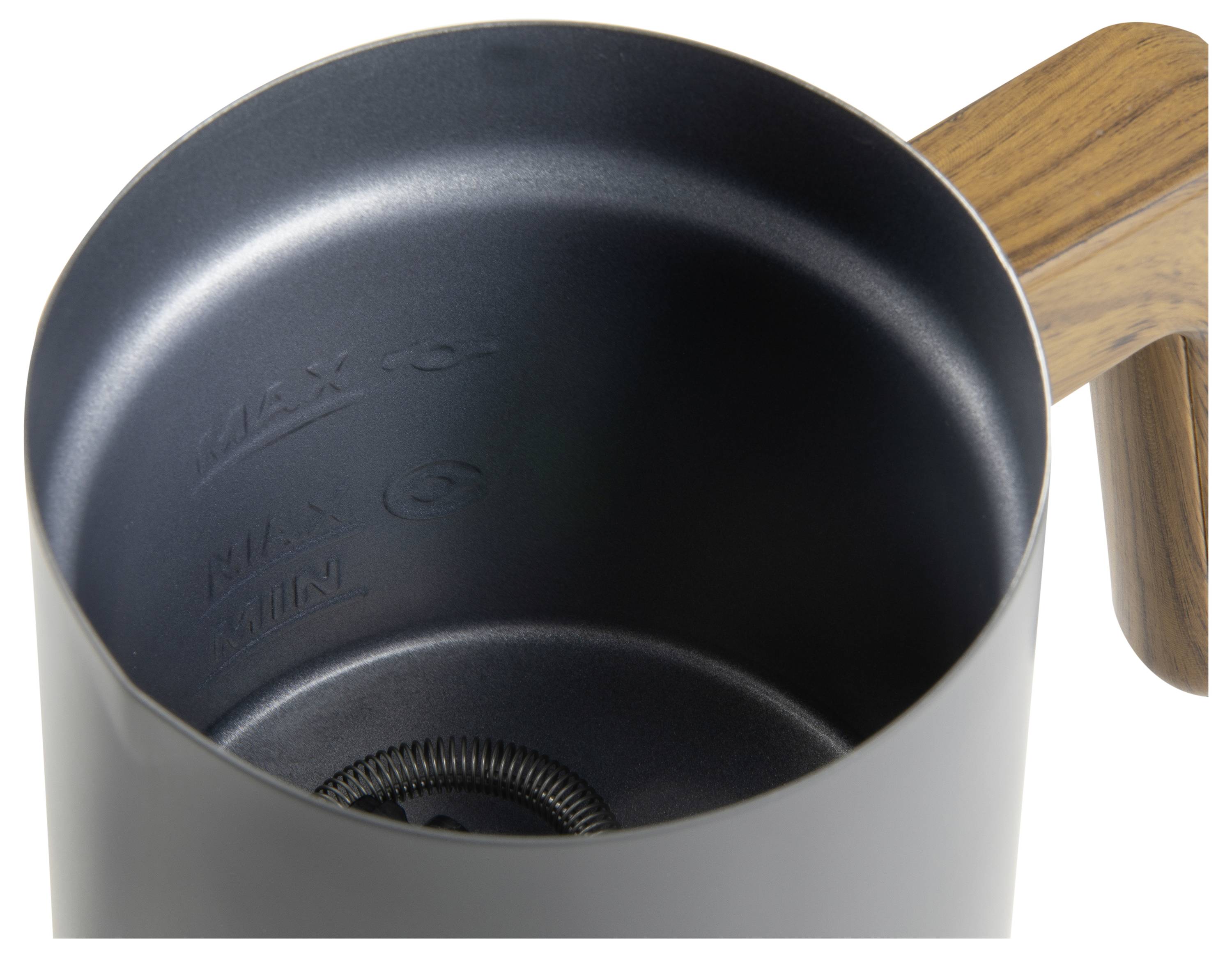 Top-Ansicht eines schwarzen Milchschaumkruges aus Metall mit Holzgriff. Im Inneren sind Markierungen für die maximale und minimale Füllhöhe sichtbar.
