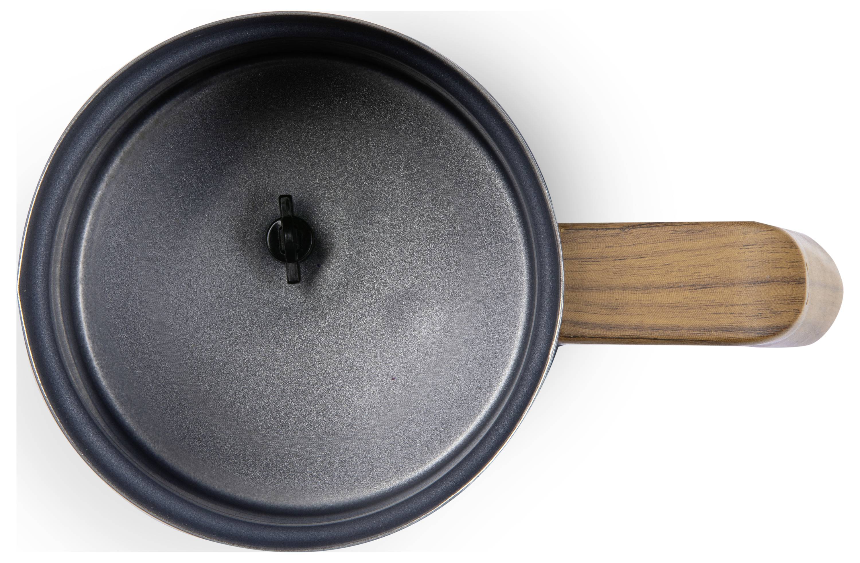 Top-Ansicht eines schwarzen Topfs mit einem Holzgriff und Deckel. Der Topf steht auf einer weißen Oberfläche.