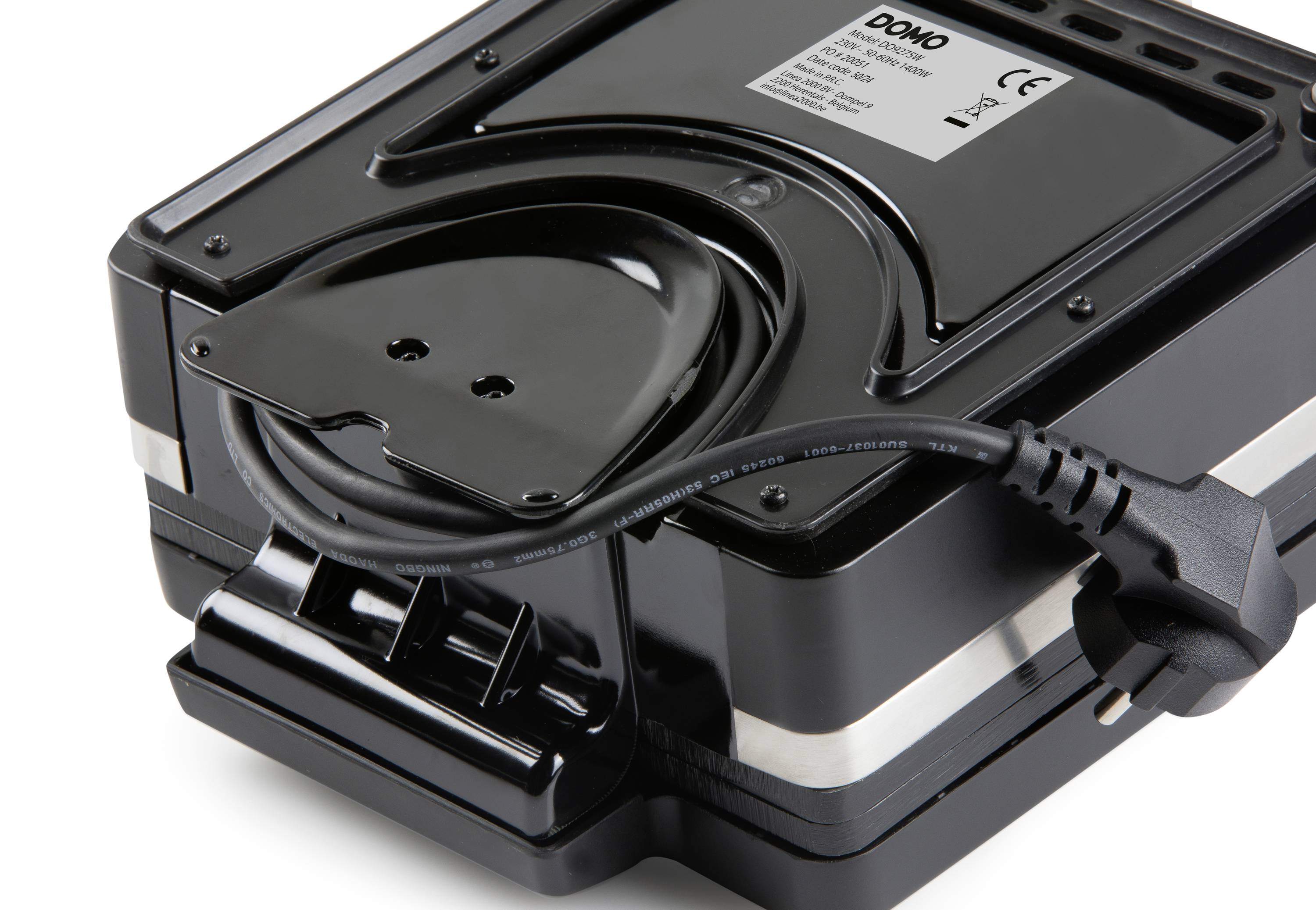 Ein schwarzes Gerät mit einem aufgerollten Stromkabel und Stecker. Ein Etikett zeigt das Markenzeichen und technische Spezifikationen.