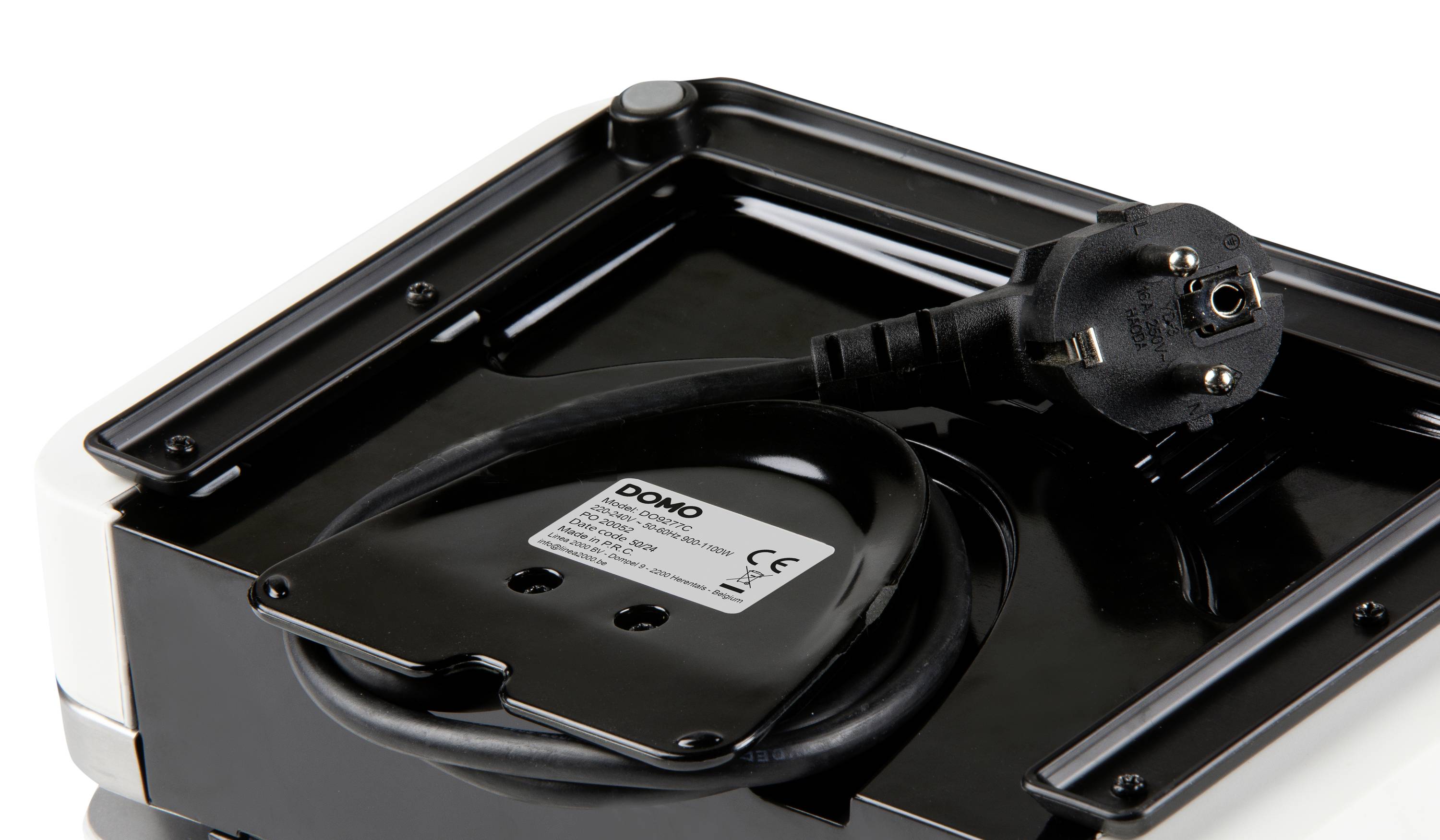 Ein schwarzes Netzteil mit Kabel und Stecker ist in einer schwarzen Halterung auf der Unterseite eines Geräts befestigt.