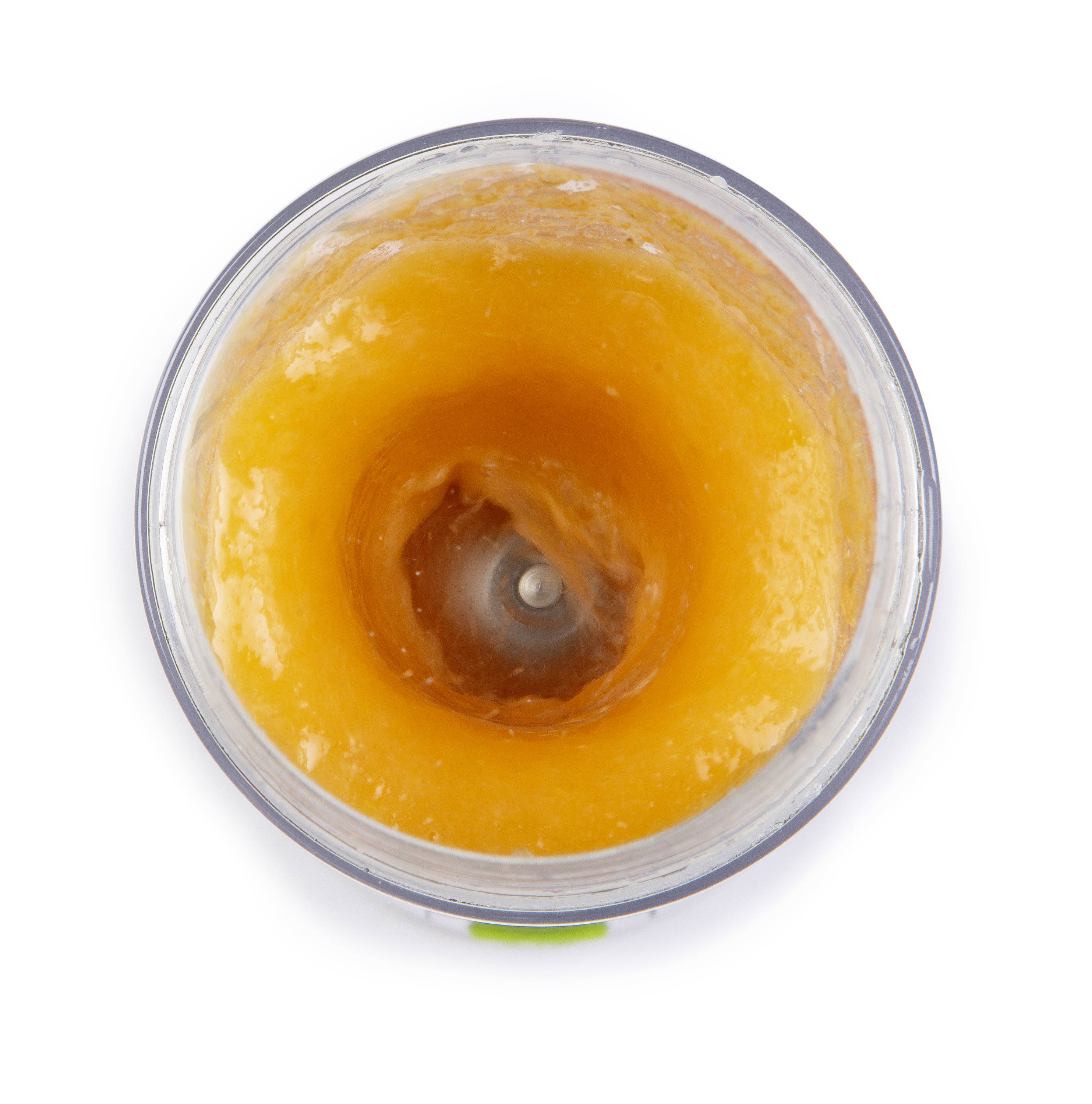 Ein Mixer von oben mit orangefarbenem Püree im Inneren, das zentrifugal gemischt wird.