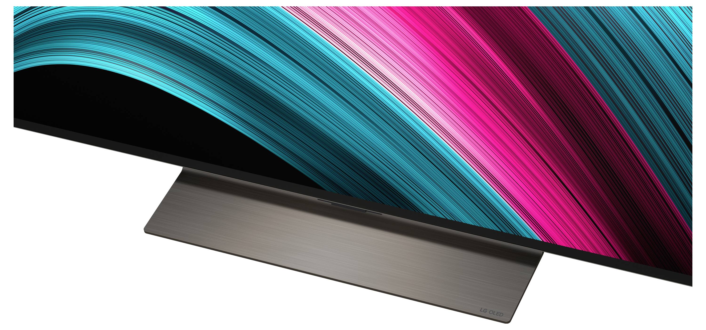 Ein schlanker, ultra-dünner Monitor mit einem lebendigen Wellenmuster aus Türkis- und Magentafarben über den Bildschirm, auf einem minimalistischen Ständer platziert.