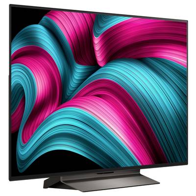 Flachbild-Fernseher, der abstrakte Kunst mit lebhaften rosa und petrolblauen wirbelnden Mustern auf schwarzem Hintergrund zeigt.
