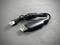 Schwarzes USB-Kabel auf grauem Hintergrund, mit einem USB-A-Stecker an einem Ende und einem kleinen weißen Stecker am anderen Ende.