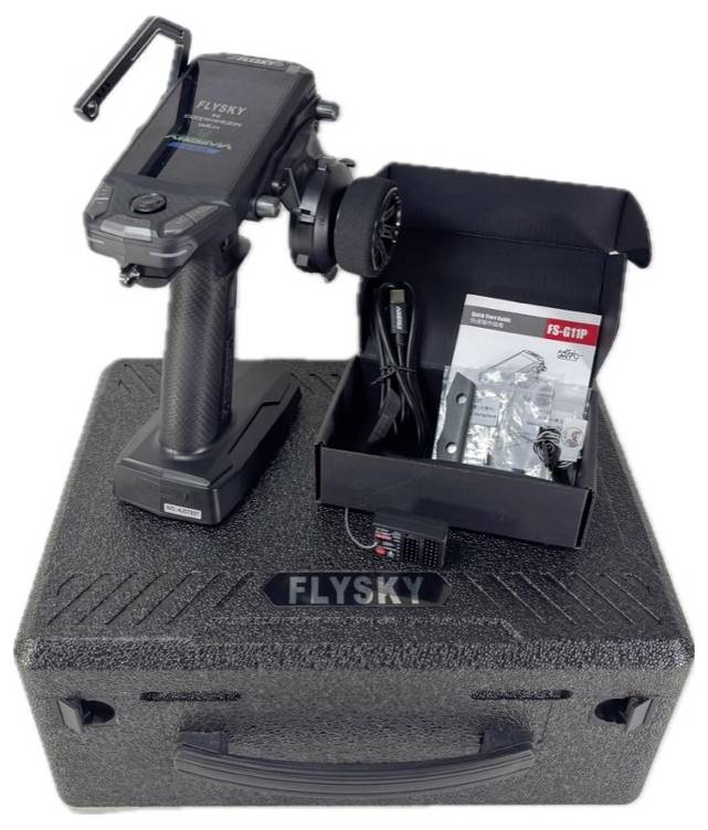 RC-Fernsteuerung mit Lenkrad und Koffer, Marke 'Flysky', Modell FS-G7P. Enthalten: Ladegerät, FS-G7P Bedienungsanleitung und Zubehör.
