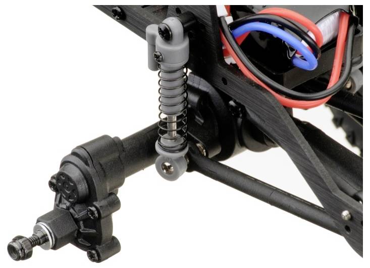 Ein Nahaufnahme eines Modellauto-Fahrwerks mit Aufhängung und Verkabelung. Es zeigt eine Feder und Stabilisator an einem schwarzen Rahmen.