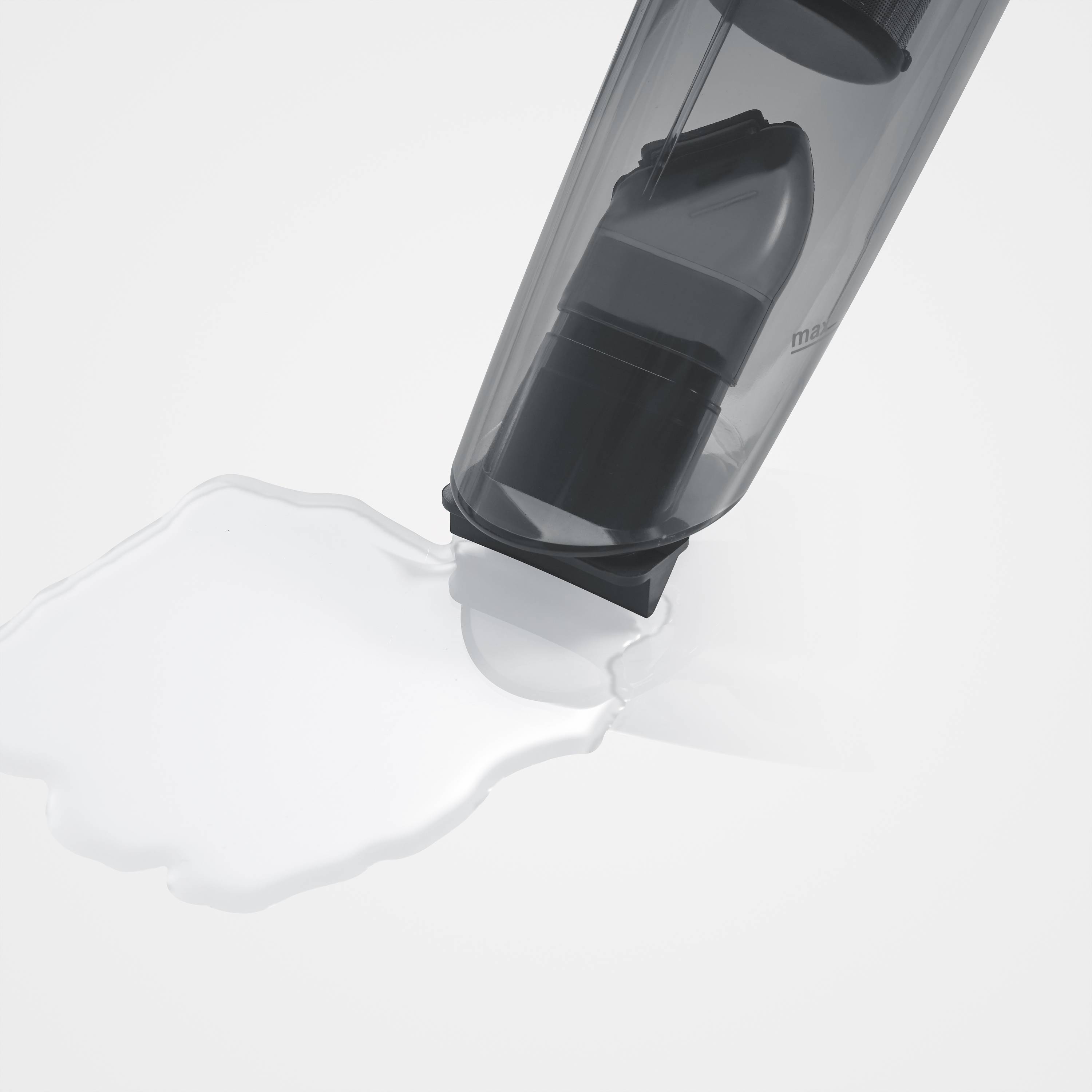 Ein umgefallener Eimer verschüttet weiße Flüssigkeit auf einer ebenen Fläche. Die Farbe der Flüssigkeit ähnelt Milch oder Farbe.