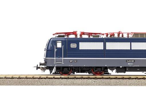 Eine blaue Modelleisenbahn-Lokomotive auf Schienensträngen, mit detaillierten Rädern und elektrischer Ausrüstung auf dem Dach, Seitenansicht.