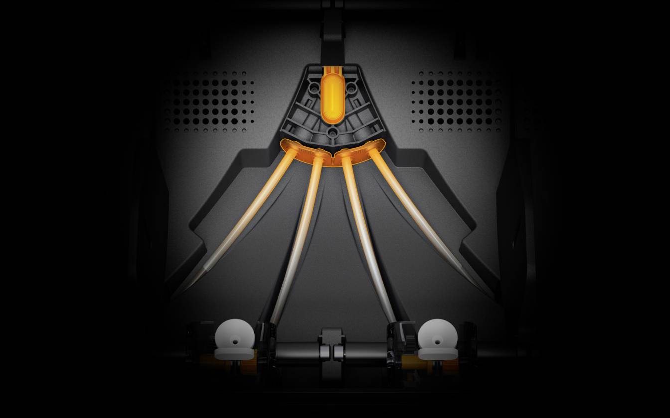 Ein technisches Gerät zeigt strahlende orangene Lichtleitungen, die sich von einem zentralen Punkt in drei Richtungen ausbreiten.