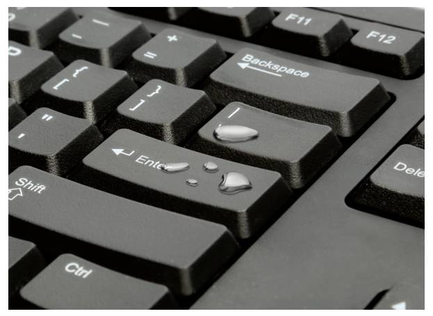 Tastatur mit Wassertropfen auf der Enter-Taste.