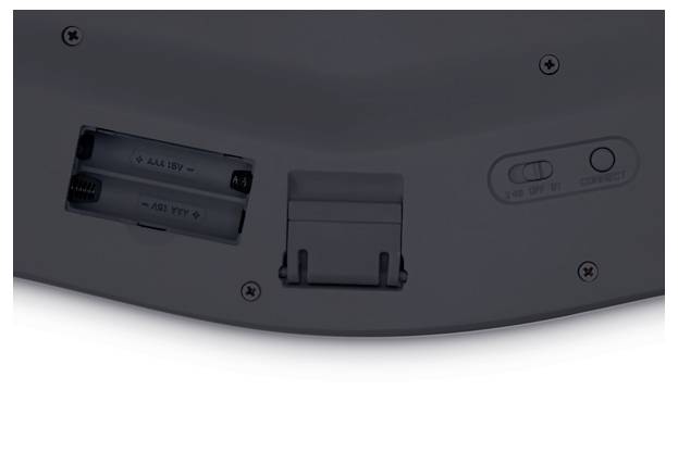 'Rückseite eines Geräts mit Batteriefach für zwei AA-Batterien und Schalter für An/Aus/Bluetooth-Verbindung.'