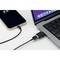Laptop und Smartphone durch ein USB-C-Kabel verbunden. Laptop zeigt geöffnete Anwendungen, Smartphone-Display zeigt Ladesymbol.