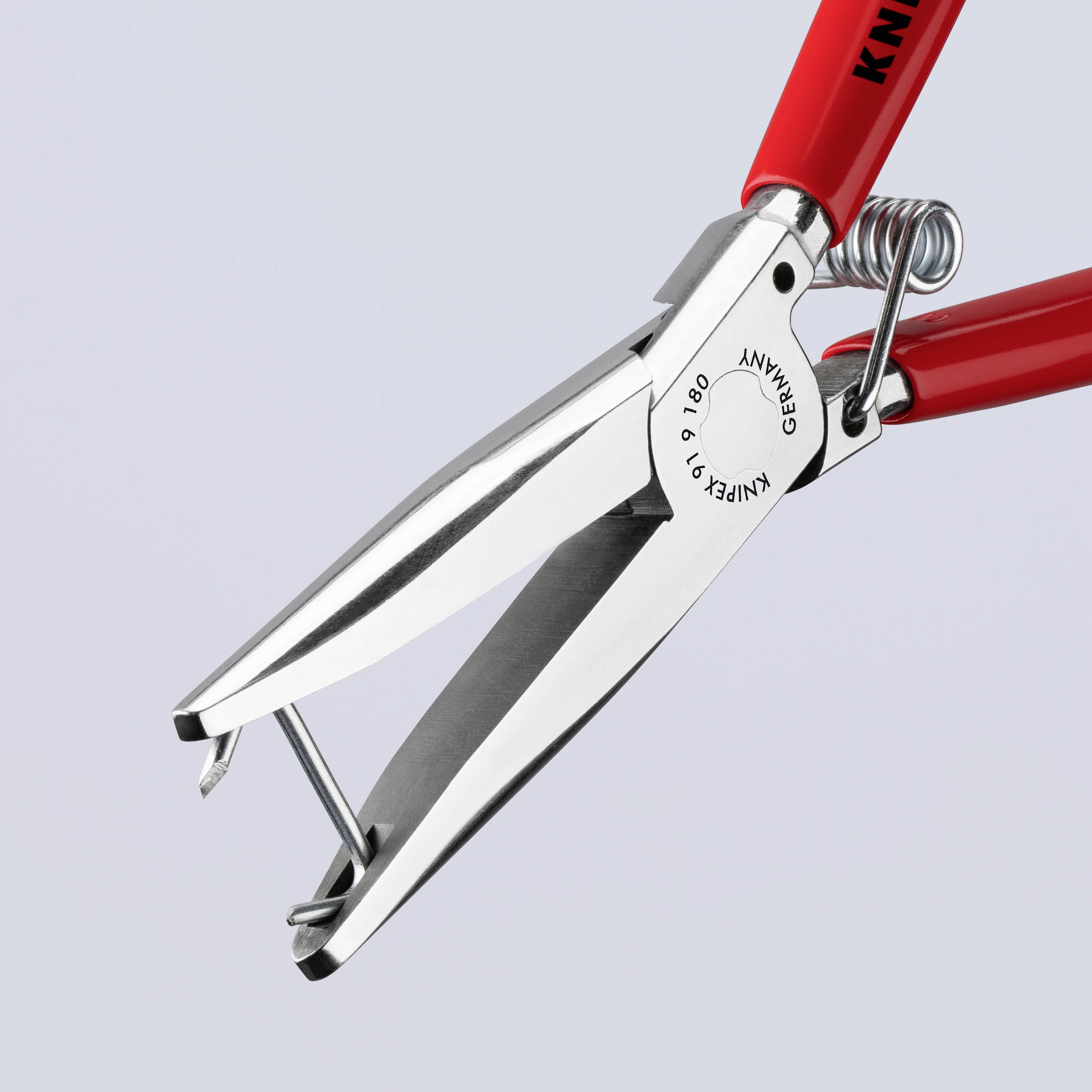 Rote Nagelknipser mit metallischen Klingen, geöffnet. Griff und Federmechanismus sichtbar. Klarer, grauer Hintergrund.