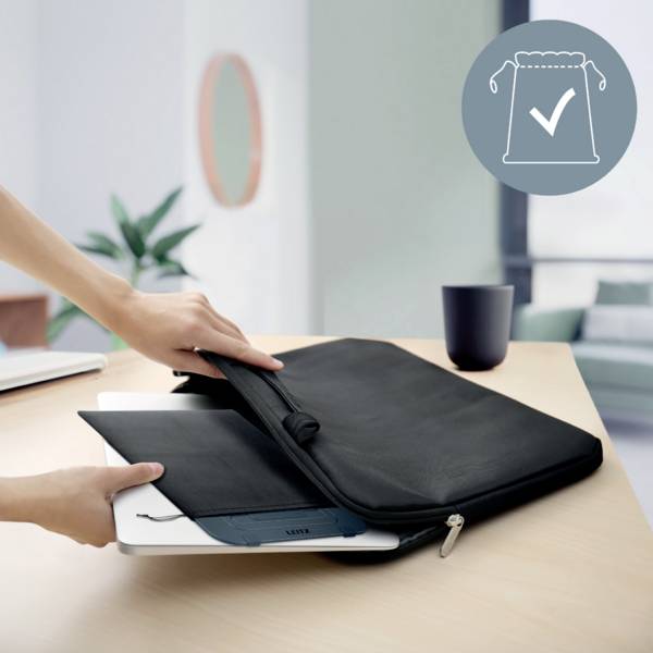 Eine Person legt einen Laptop in eine schwarze Hülle auf einem Tisch. Im Hintergrund sind Pflanzen und ein Sofa zu sehen. Oben rechts: ein Icon mit einem Häkchen in einem Beutel.