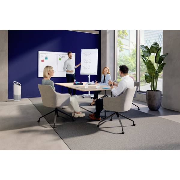 Vier Personen diskutieren in einem modernen Büro mit Whiteboards im Hintergrund. Ein Mann steht und präsentiert Informationen.