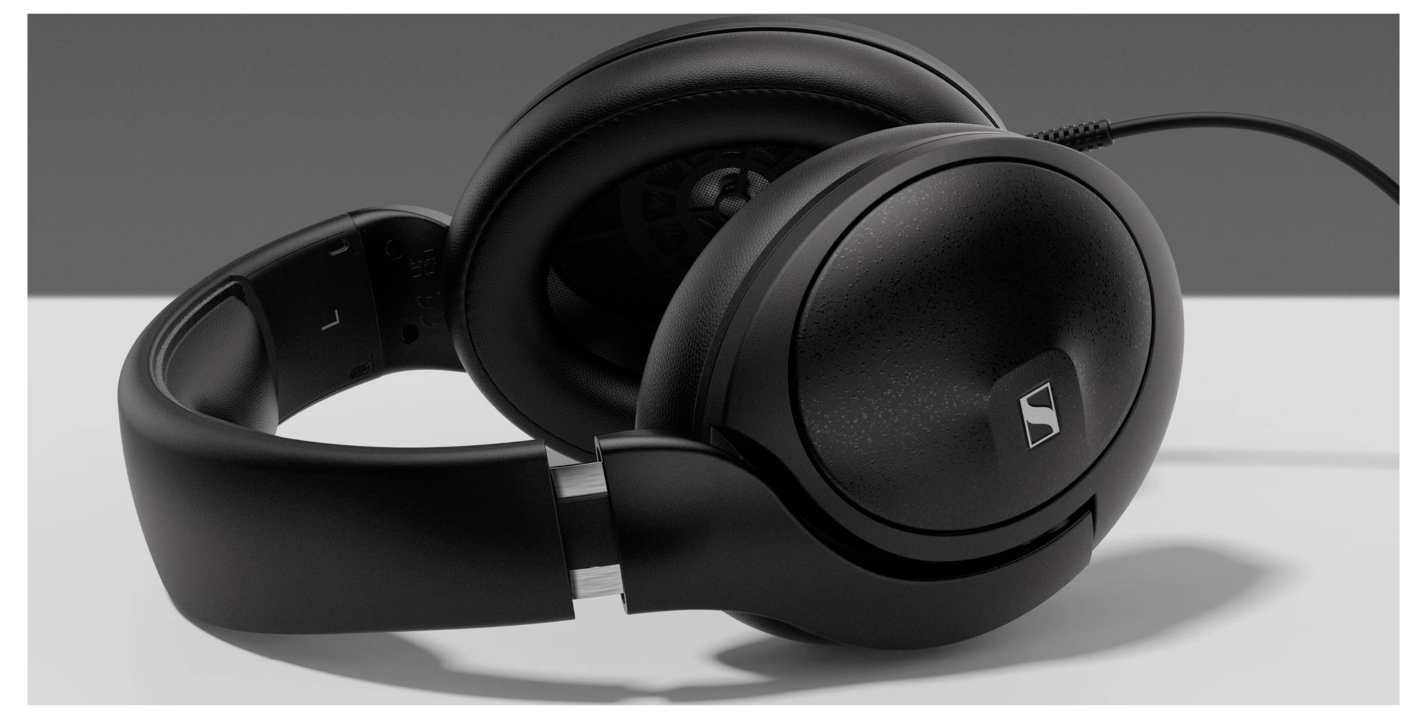 Schwarze, kabelgebundene Over-Ear-Kopfhörer liegen auf einem Tisch. Sie sind für Musikgenuss oder Computer-Audioanwendungen geeignet.