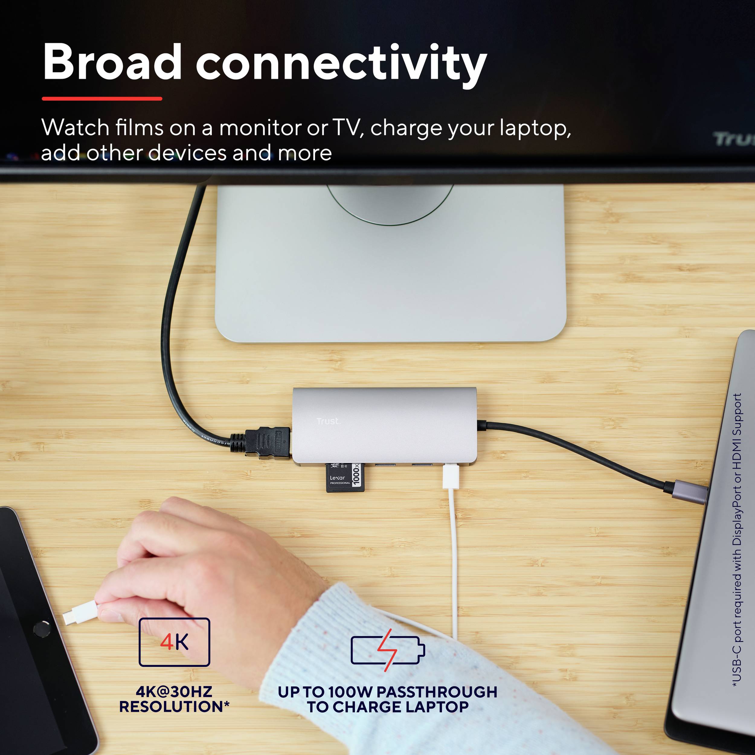 Ein grauer Adapter verbindet ein Laptop mit HDMI und USB-C für Bildschirmausgabe und Laptop-Ladung. Text: '4K @30Hz', 'Bis zu 100W Ladeleistung'.