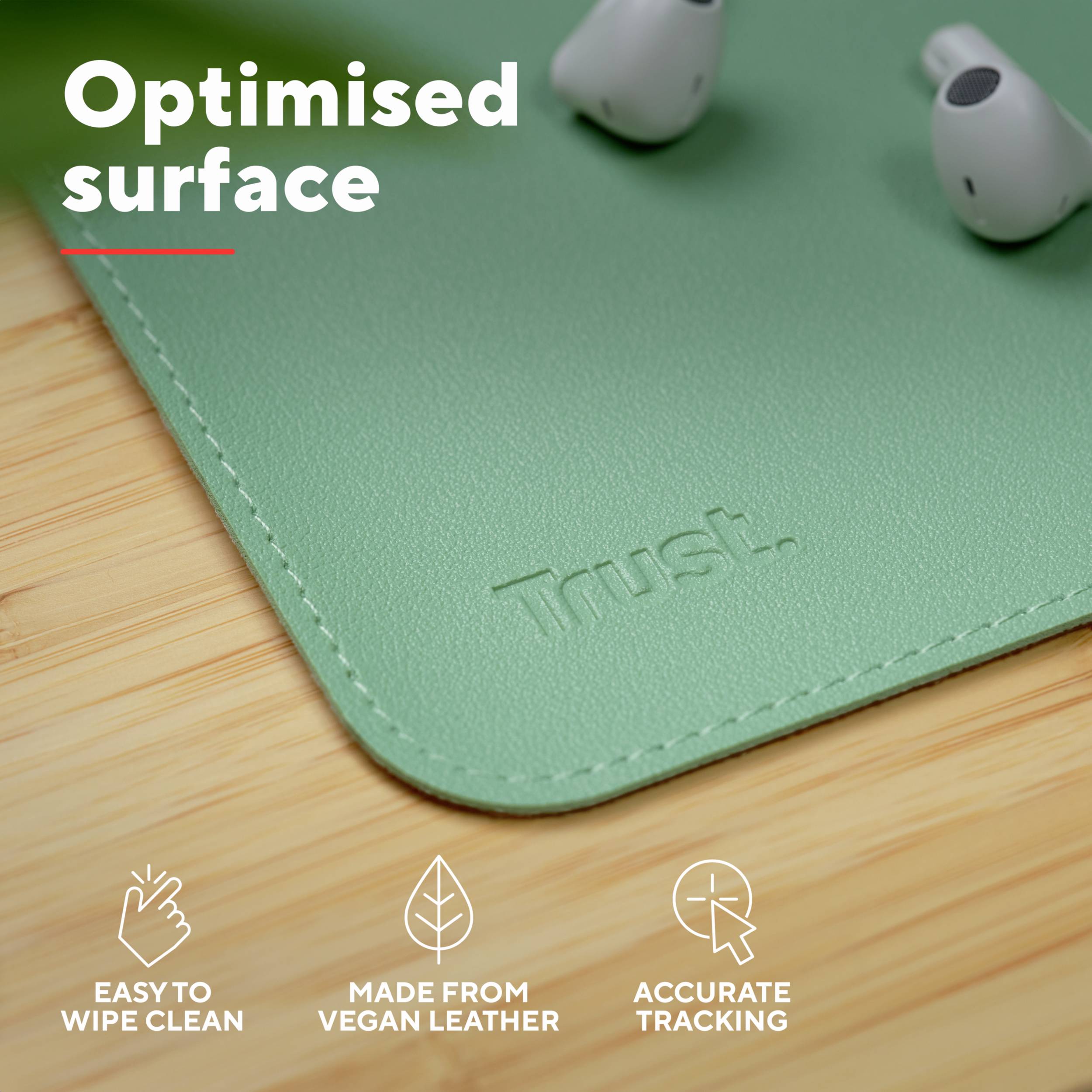 'Optimised surface' in Weiß auf grünem Mauspad aus veganem Leder; AirPods daneben; Symbole für einfache Reinigung, veganes Leder, präzises Tracking.