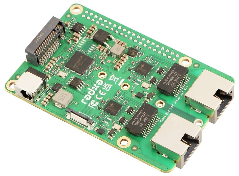 Grüne Leiterplatte mit mehreren schwarzen Chips, weißen Anschlüssen und dem weißen Aufdruck 'radxa'.