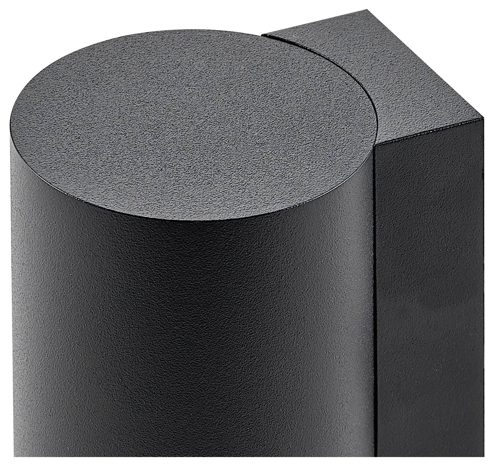 Zylindrisches Objekt mit metallischer, schwarzer Oberfläche neben einem quadratischen Objekt. Minimalistisches, industrielles Design.