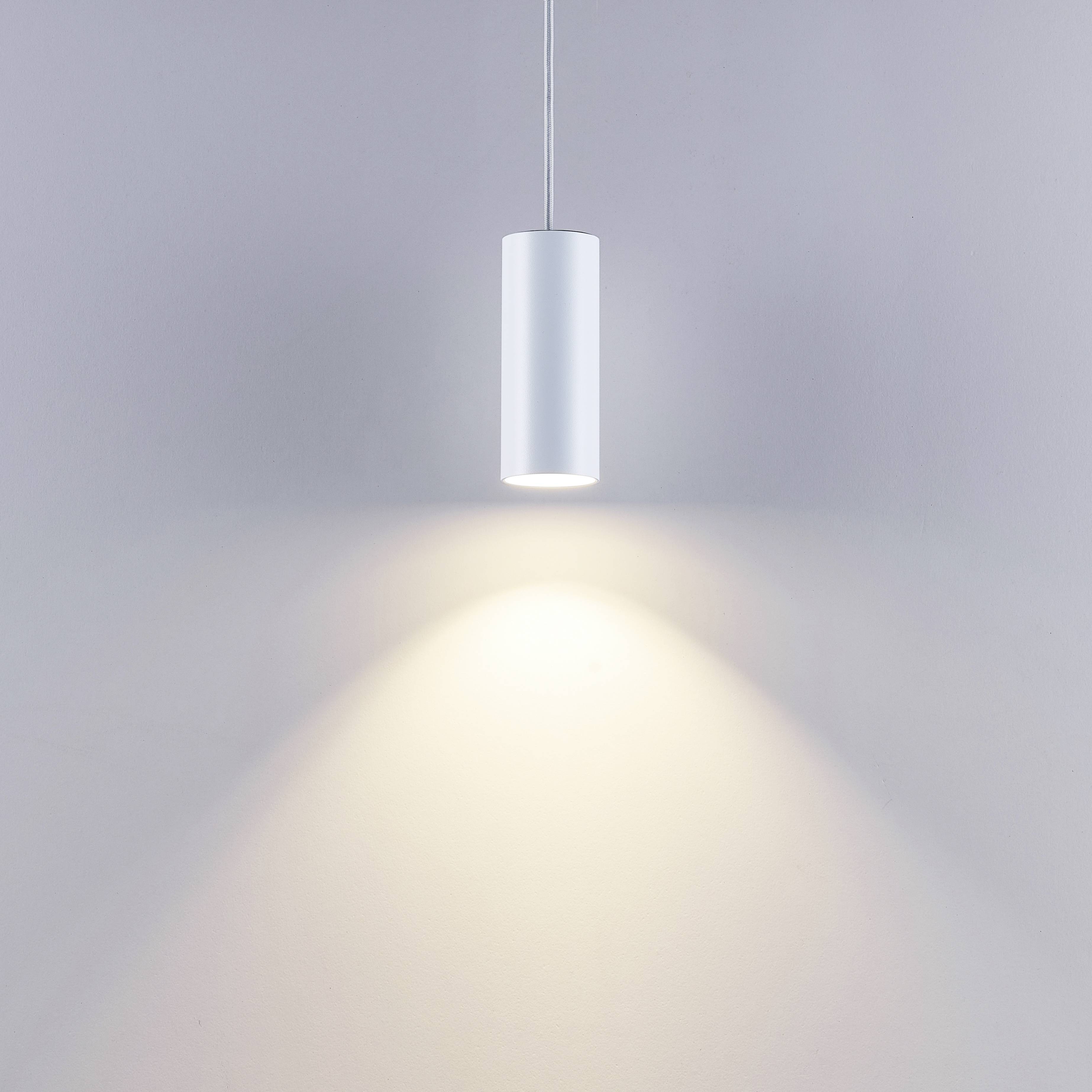 Hängende weiße Zylinderlampe mit einem leuchtenden Lichtkegel auf einer hellen Wand.
