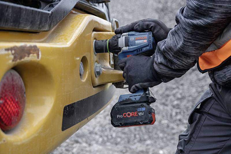 Eine Person bedient einen Bosch-Akkubohrschrauber ProCORE18V, um Schrauben in eine gelbe Metalloberfläche zu schrauben.
