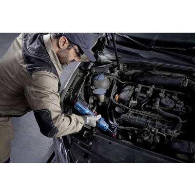 Ein Mechaniker arbeitet mit einem Diagnosegerät am Motor eines Autos in einer Werkstatt, trägt Schutzkleidung und -brille.
