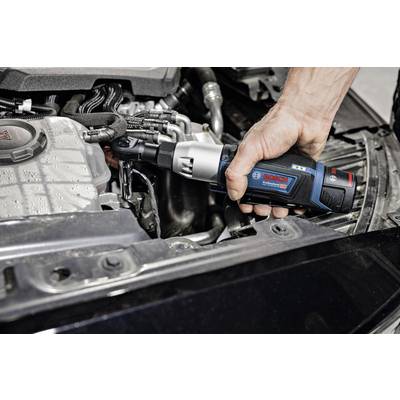 Eine Hand hält einen Bosch-Akku-Drehschlagschrauber und arbeitet an einem offenen Automotor.