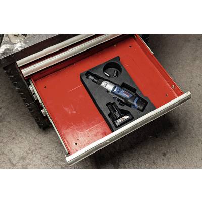 Eine geöffnete Werkzeugschublade enthält einen elektrischen Schraubendreher mit Akku und Ladestation auf rotem Hintergrund.