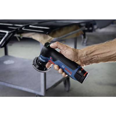 Eine Person hält ein Bosch-Akku-Schleifgerät vor einem metallischen Hintergrund.