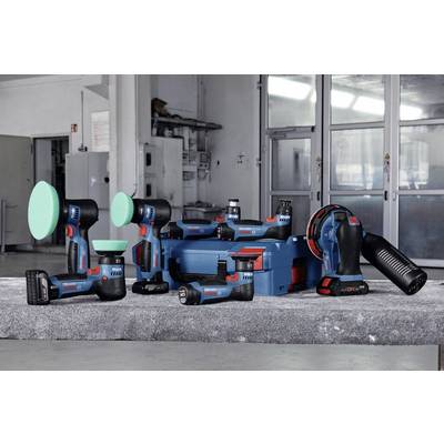 Diverse Elektrowerkzeuge und Zubehör auf grauem Tisch in Werkstatt, darunter Bohrer, Polierer und Akkuladegerät.