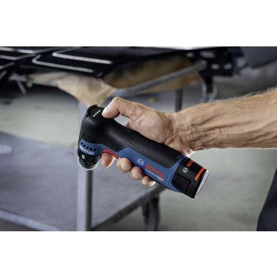 Eine Hand hält einen blauen und schwarzen Bosch-Akkuschrauber mit rotem Logo; das Werkzeug wird in einer Werkstatt verwendet.