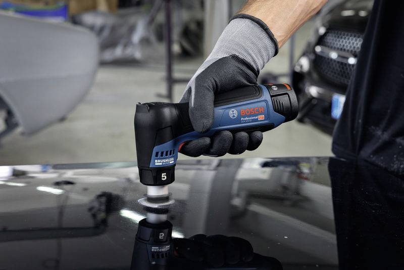 Ein Handwerker poliert mit einem Bosch Profi-Poliergerät eine glänzende, schwarze Oberfläche in einer Werkstatt.