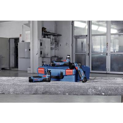 Akkuschrauber-Set mit blauen und roten Werkzeugen vor grauem Hintergrund in einer Werkstatt, deutlich sichtbar auf einem Tisch platziert.