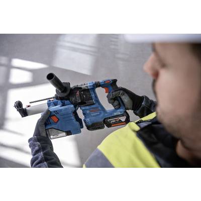 Eine Person hält einen blauen Bohrhammer mit schwarzem Griff. Die Person trägt Sicherheitskleidung, einschließlich Handschuhe und Helm.