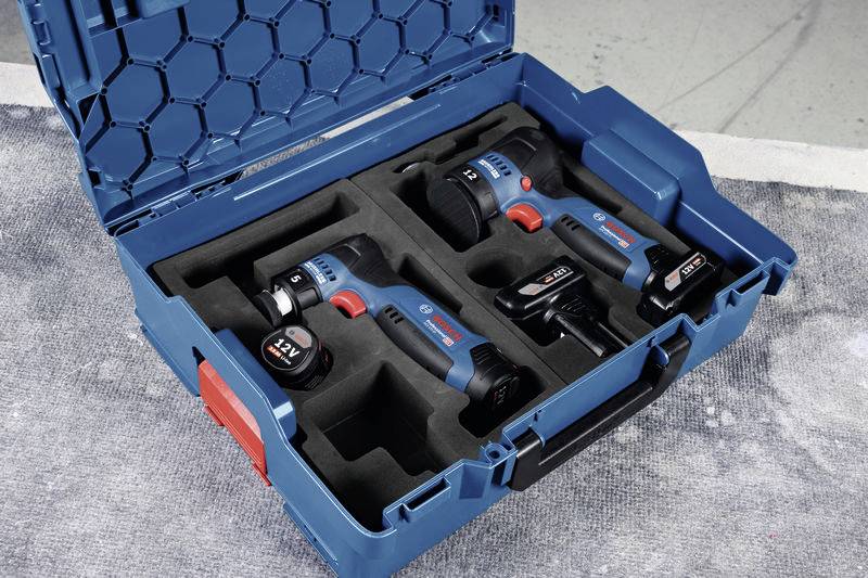 Ein offener Werkzeugkoffer enthält zwei blaue Akkubohrschrauber mit Batterien, gut gepolstert und organisiert für einfachen Transport.