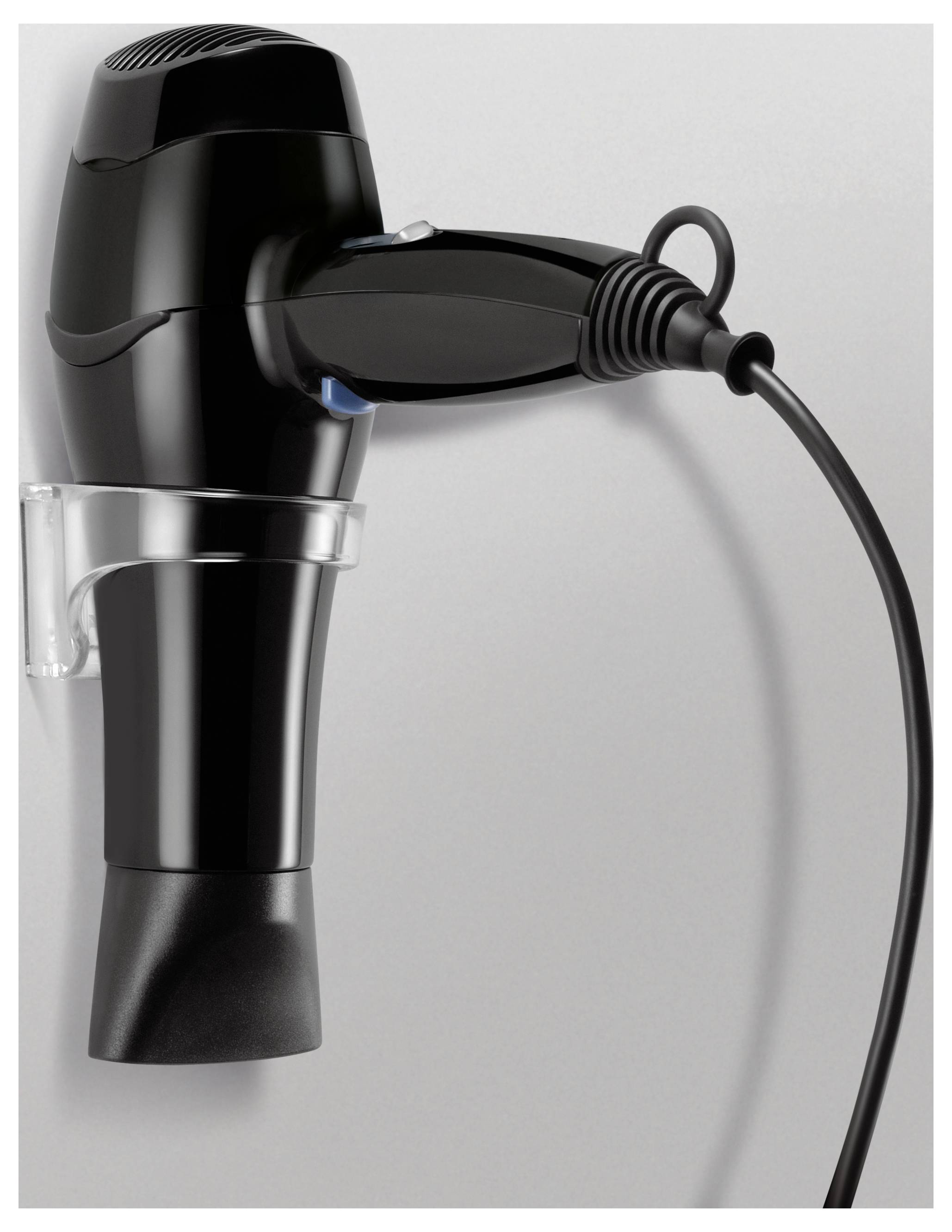 Ein schwarzer Haartrockner hängt an einer weißen Wandhalterung, das Kabel ist eingesteckt.