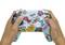 Zwei Hände halten einen bunten Videospiel-Controller mit Aufklebern.